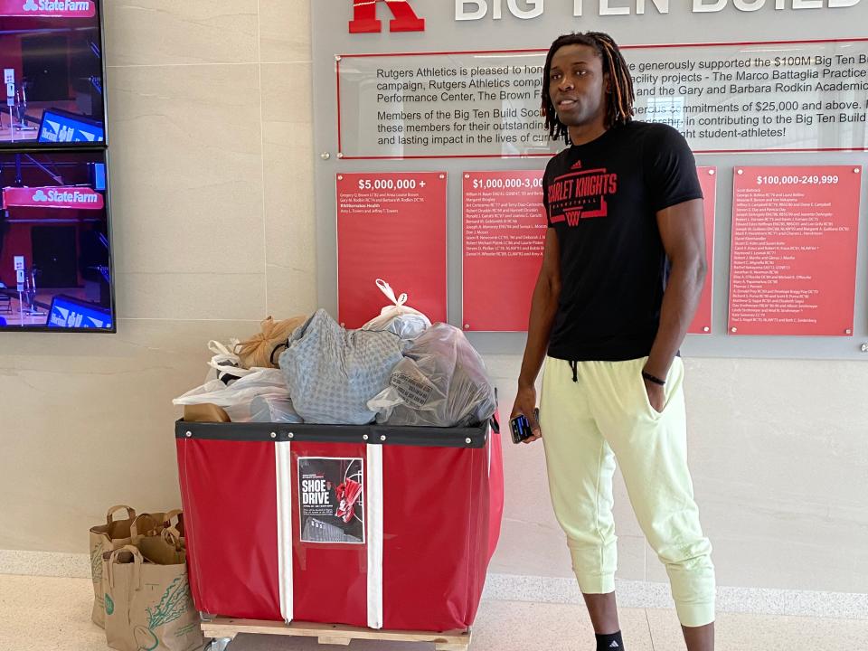 Rutgers center Cliff Omoruyi stands next to a bin filled with shoes as part of a shoe drive he is running this week to benefit those in need in his come country of Nigeria.