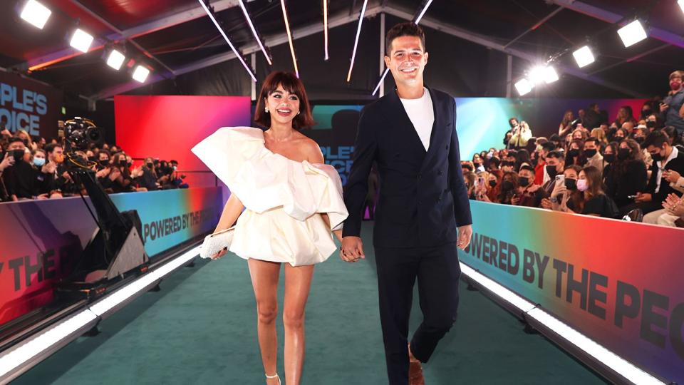 (l-r) Sarah Hyland and Wells Adams arrive to the 2021 People's Choice Awards held at Barker Hangar on December 7, 2021 in Santa Monica, California.