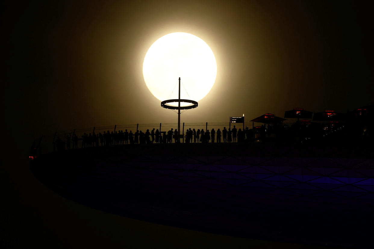 Tiny outlines of people from a distance as they watch the first supermoon of the year rise at Marina Bay Sands hotel in Singapore.