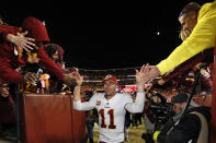 FILE - Washington Redskins quarterback Alex Smith (11) celebrates with fans after an NFL football game against the Dallas Cowboys in Landover, Md., in this Sunday, Oct. 21, 2018, file photo. Smith earned AP Comeback Player of the Year honors for getting back on the field last season, two years removed from his gruesome injury that required 17 surgeries to repair. Alex Smith is retiring from the NFL after making an improbable comeback from a broken leg. Smith announced his retirement Monday, April 19, 2021, on Instagram, saying he still has plenty of snaps left him just shy of his 37th birthday but is calling it quits to enjoy time with his family.(AP Photo/Alex Brandon, File)