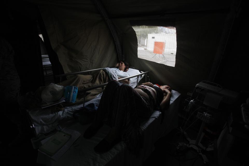 Preganant women wait for their turn at a delivery ward within a Chilean Army field hospital, in Iquique, Chile, Friday, April 4, 2014. Coastal residents of Chile's far north have spent sleepless nights outside their homes as aftershocks continued following a magnitude-8.2 earthquake early in the week that damaged several thousand homes and caused six deaths. (AP Photo/Luis Hidalgo).