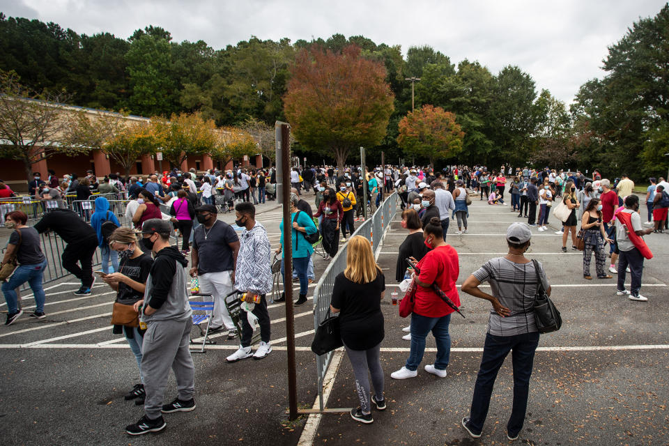 FILE - Hundreds of people wait in line for early voting on Oct. 12, 2020, in Marietta, Ga. State Election Board member Matt Mashburn testified at a hearing on Monday, July 18, 2022, that conduct he witnessed at this polling place led him to conclude it was necessary for the state to ban all gifts to waiting voters, including food and water. (AP Photo/Ron Harris, File)