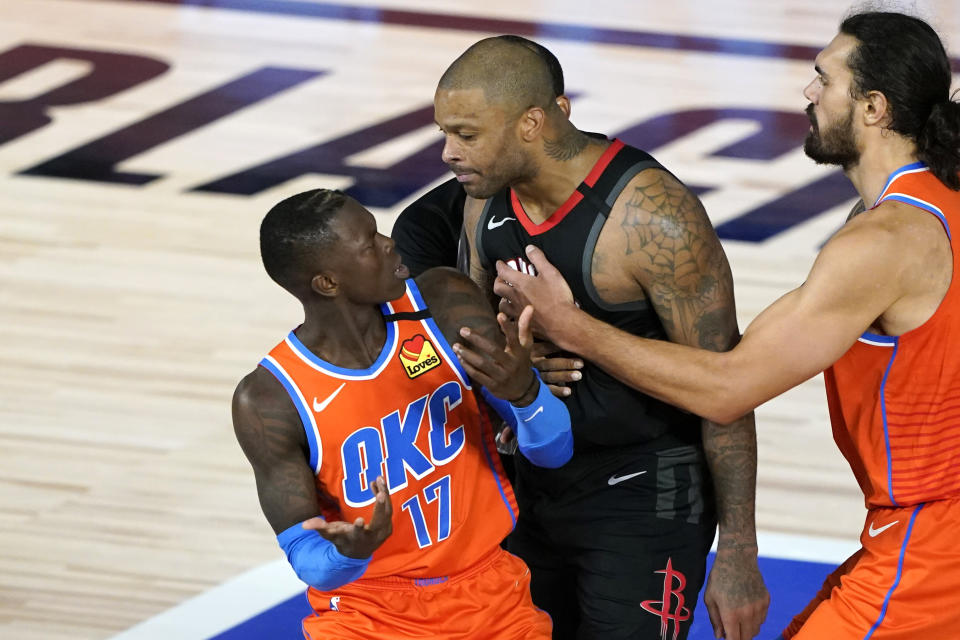 Houston Rockets' P.J. Tucker, center, his held back by Oklahoma City Thunder's Steven Adams, right, as he confronts Dennis Schroder (17) after a foul during the second half of an NBA basketball first round playoff game Saturday, Aug. 29, 2020, in Lake Buena Vista, Fla. Both players were ejected. Both Schroder and Tucker were ejected from the game. (AP Photo/Ashley Landis)