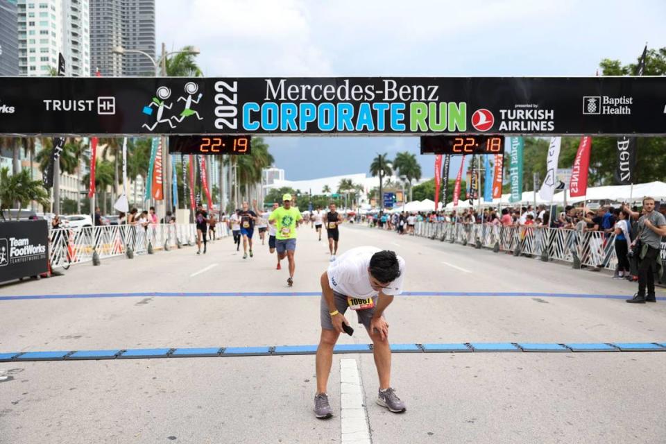 A man rests after crossing the finish line during the Mercedes-Benz Miami Corporate Run starting at Bayfront Park in Miami on Thursday, April 28, 2022.