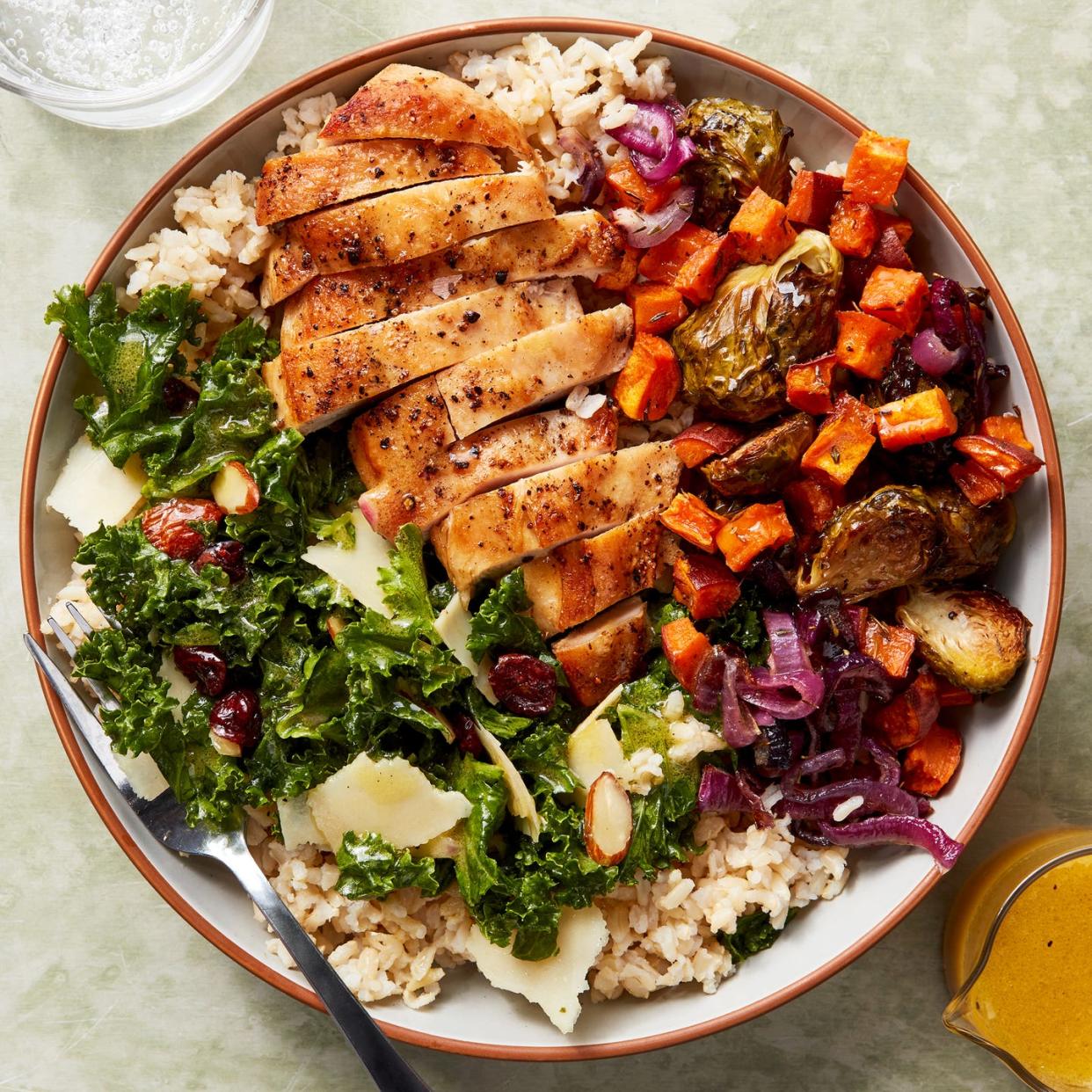 chicken, kale salad, and roasted sweet potatoes in a rice bowl