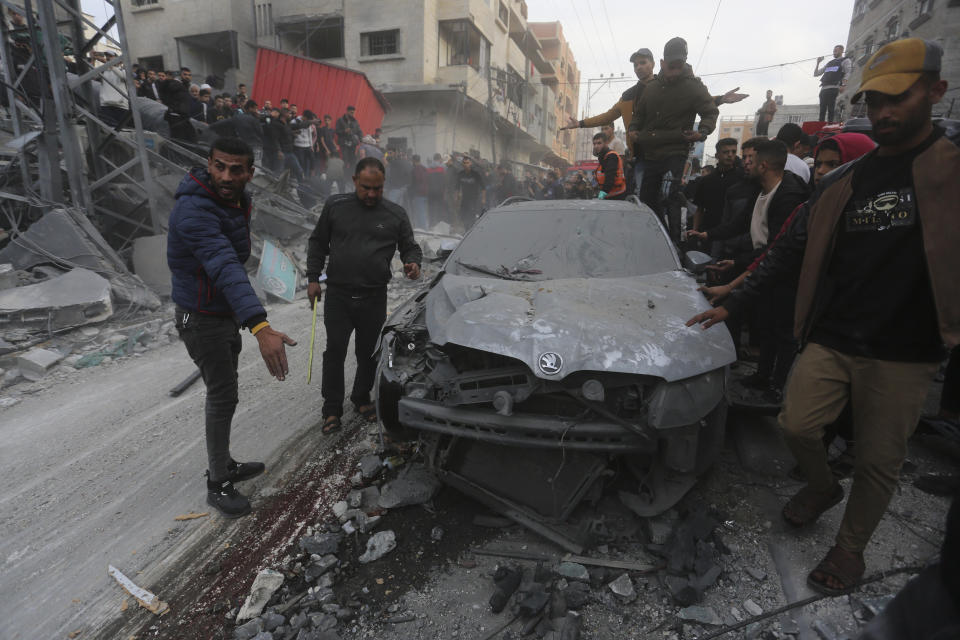 Palestinians look at the destruction after an Israeli strike in Rafah, Gaza Strip, Wednesday, Dec. 20, 2023. (AP Photo/Hatem Ali)
