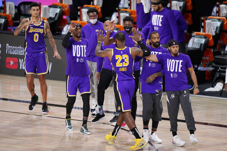 Los Angeles Lakers' LeBron James (23) celebrates with teammates during a timeout in the final moments of an NBA conference final playoff basketball game against the Denver Nuggets Saturday, Sept. 26, 2020, in Lake Buena Vista, Fla. The Lakers won 117-107 to win the series 4-1. (AP Photo/Mark J. Terrill)