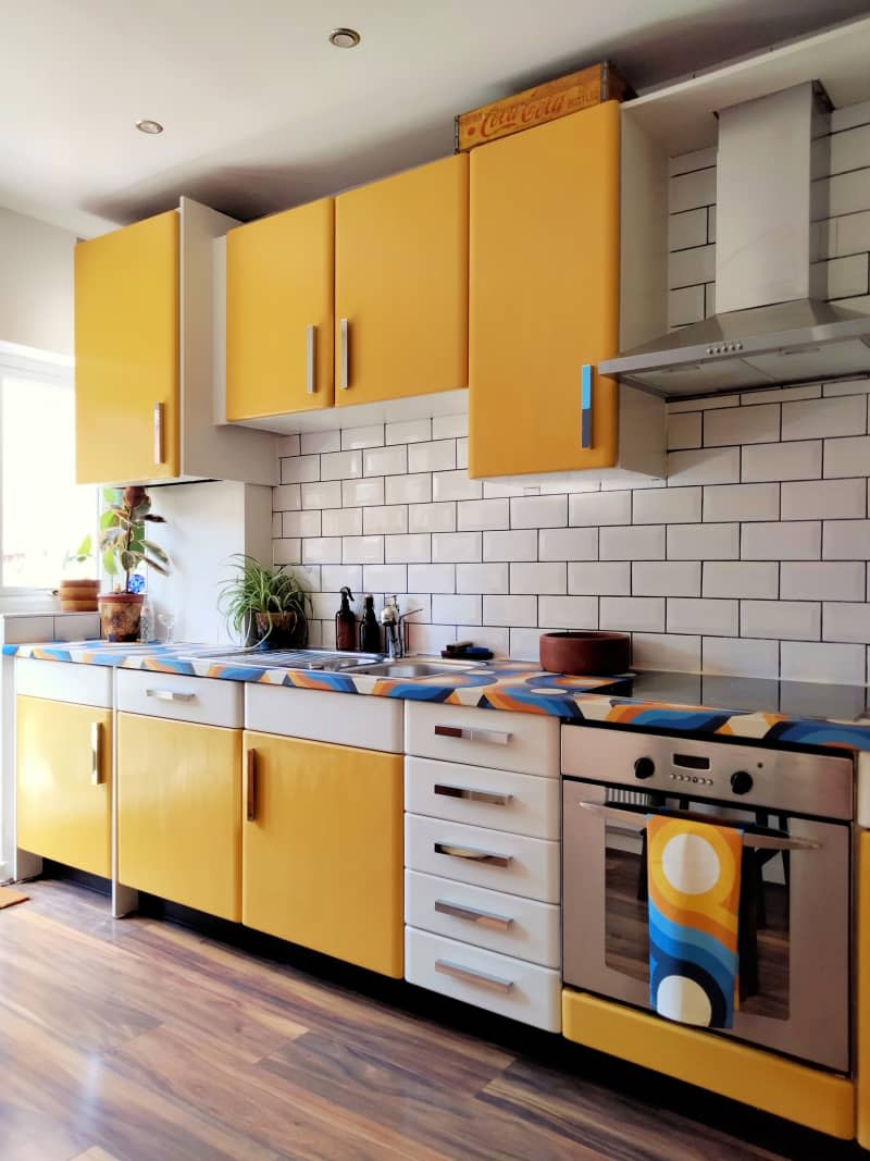 Kitchen with yellow and cabinet doors and tile backsplash.