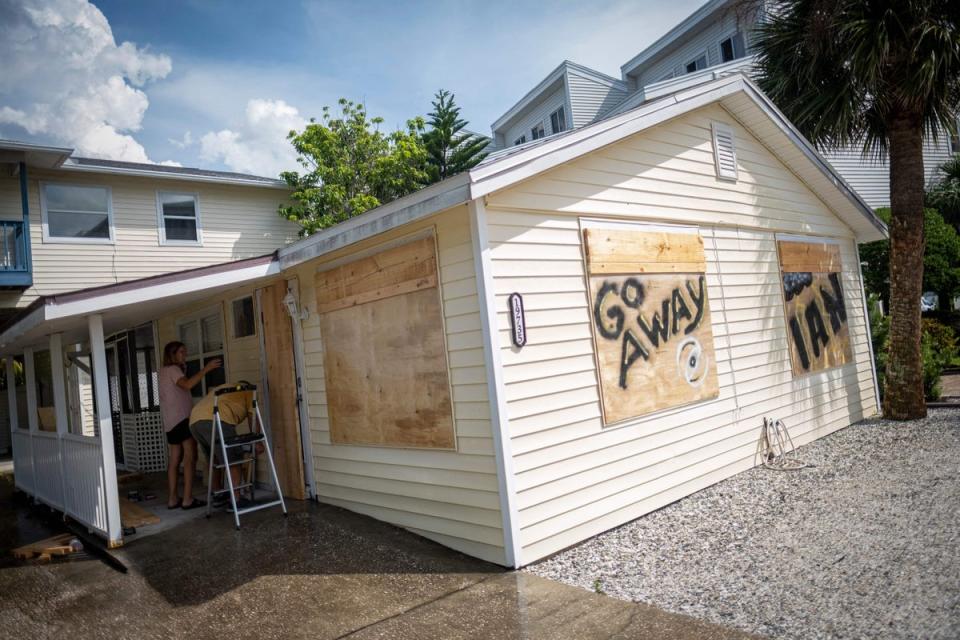 Danny Aller and his wife Karen board up windows as they prepare for the arrival of Hurricane Ian in Indian Shores, 25 miles West of Tampa, Florida on September 26, 2022. (AFP via Getty Images)