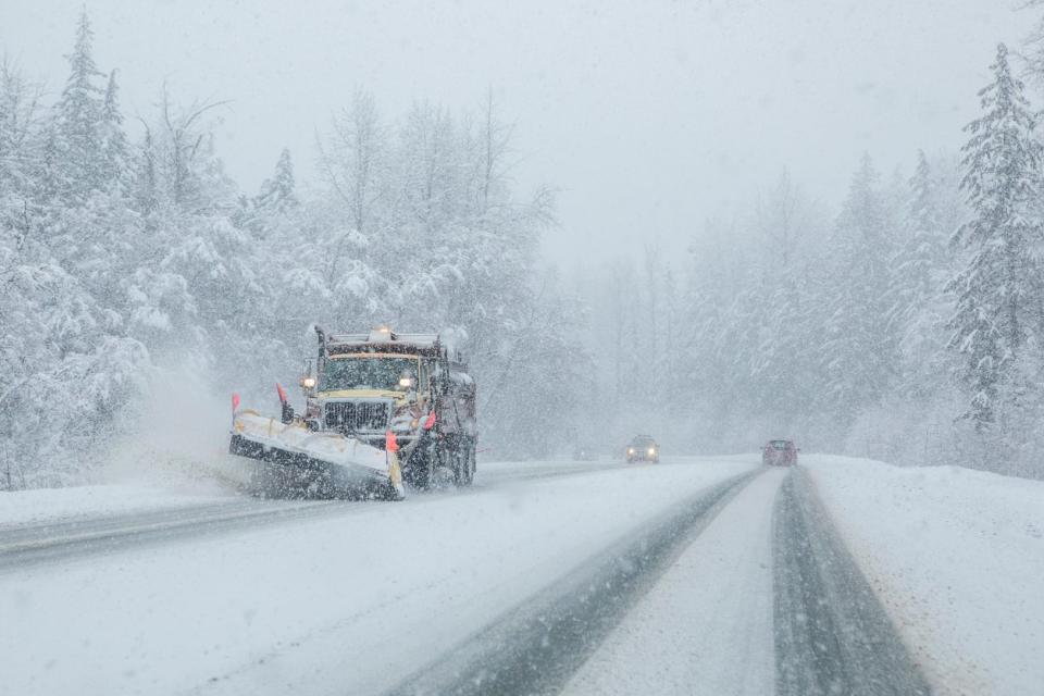 Plow truck on snowy roads with low visibility. 