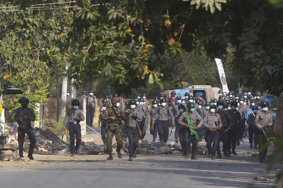 Myanmar riot police crossing blockage during a protest against the military coup in Mandalay, Myanmar, Sunday, Feb. 28, 2021. Security forces in Myanmar used lethal force as they intensified their efforts to break up protests a month after the military staged a coup. At least four people were reportedly killed on Sunday. (AP Photo)