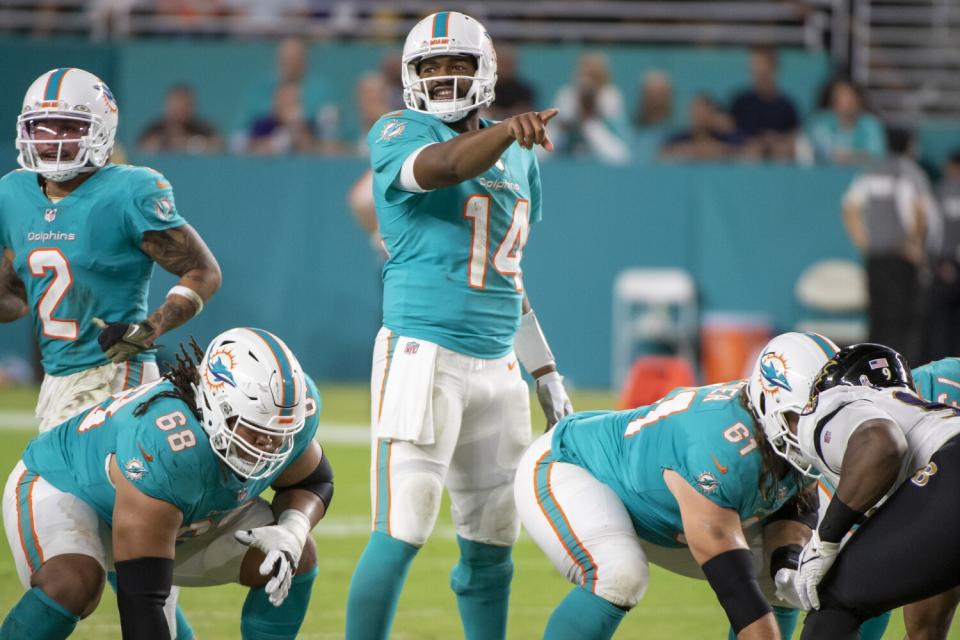 Miami Dolphins quarterback Jacoby Brissett gestures at the line of scrimmage.