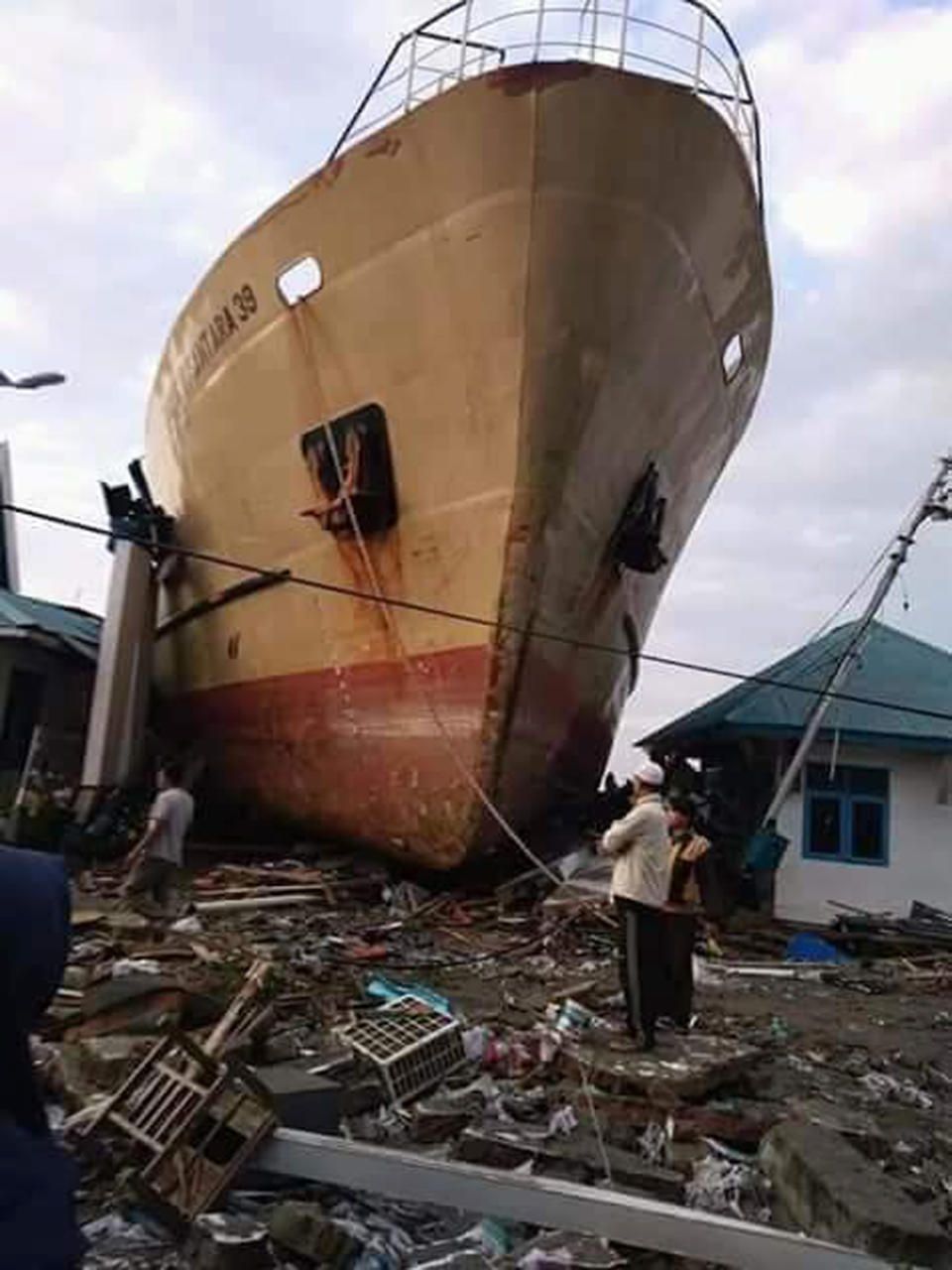 In this Saturday, Sept. 29, 2018, file photo, villagers view a ship swept ashore by a tsunami in Palu, Central Sulawesi, Indonesia. (AP Photo/Rio Mario, File)