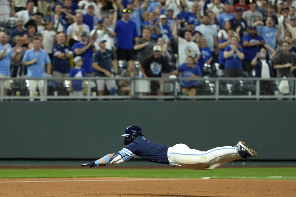 Kansas City Royals' Bobby Witt Jr. dives to third after hitting an RBI triple during the ninth inning of a baseball game against the Seattle Mariners Friday, June 7, 2024, in Kansas City, Mo. The Royals won 10-9. (AP Photo/Charlie Riedel)