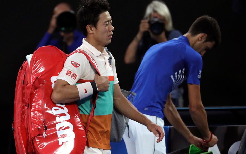 Kei Nishikori walks off Rod Laver after retiring against Novak Djokovic - AP