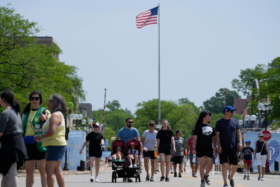 People participate in a community walk in Highland Park,  Ill., Tuesday, July 4, 2023. One year after a shooter took seven lives at the city's annual parade, community members are planning to honor the victims and reclaim the space to move forward.