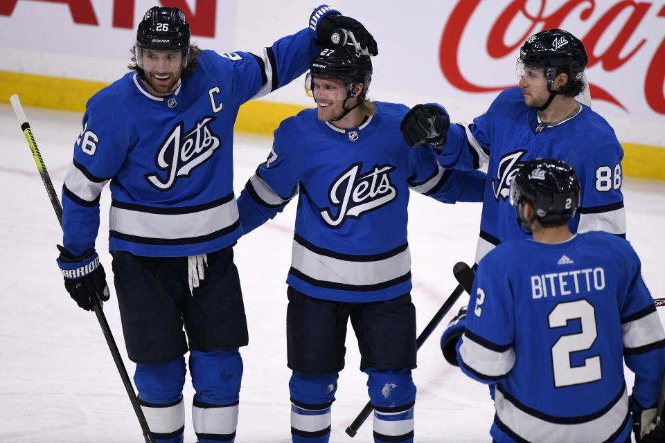 Winnipeg Jets' Nikolaj Ehlers (27) celebrates his goal against the Philadelphia Flyers with teammates Blake Wheeler (26), Nathan Beaulieu (88), and Anthony Bitetto (2) during first-period NHL hockey game action in Winnipeg, Manitoba, Sunday, Dec. 15, 2019. (Fred Greenslade/The Canadian Press via AP)