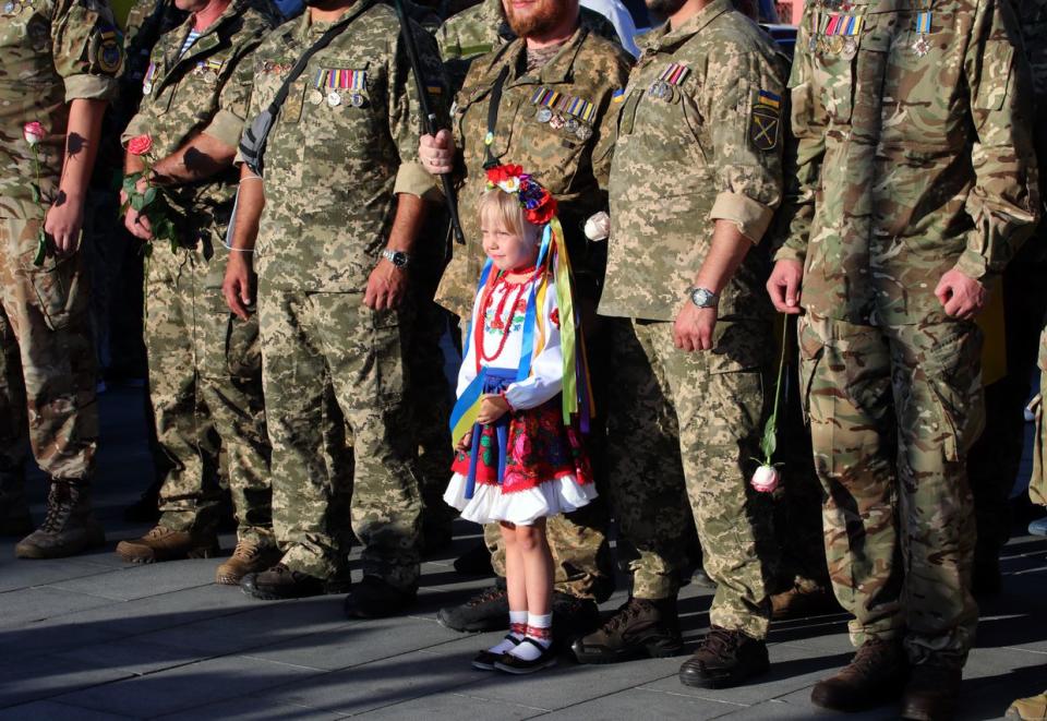 A girl in traditional Ukrainian clothes stays by men in camouflage uniforms during a march on the 29th Independence Day, Kharkiv, Ukraine, Aug. 24, 2020. (Vyacheslav Madiyevskyy/ Ukrinform/Future Publishing via Getty Images)