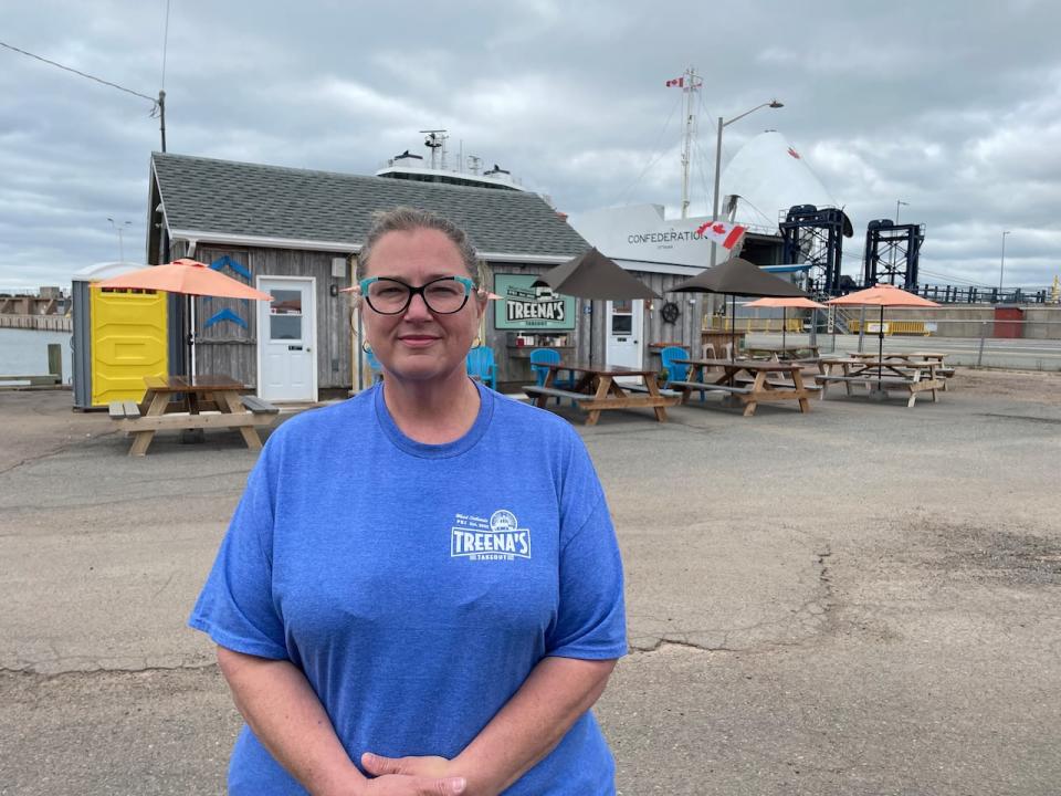 Treena MacLeod, owner of Treena's Takeout on the wharf in Wood Islands, P.E.I. stands with the MV Confederation looming large over the roof of her business. 