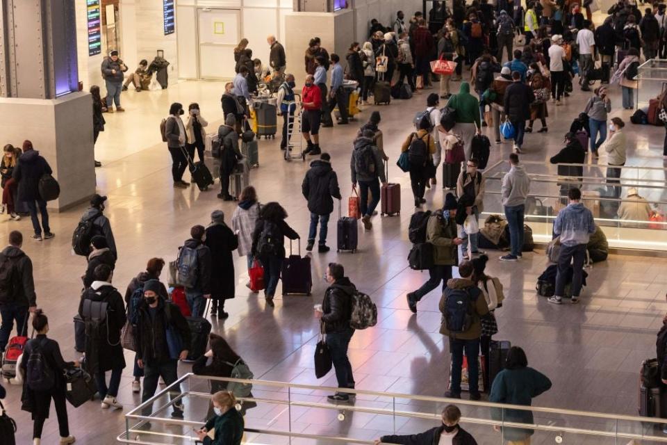 Passengers wait for trains at Moynihan Station in New York on 24 November (AFP via Getty Images)