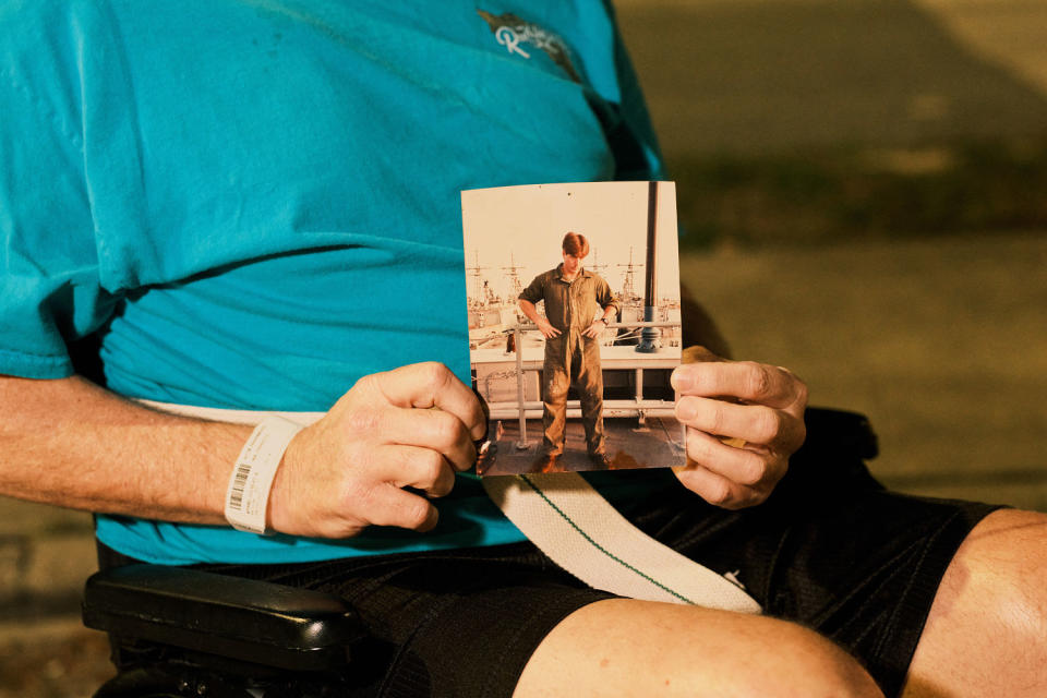 Gilbert “Kip” Wyand holds a photo of himself at the shipyard. (Zack Wittman for NBC News)