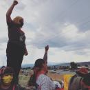 Protesters raise their fists following the removal of a statue of Spanish colonial ruler Juan de Onate, in Alcalde, New Mexico