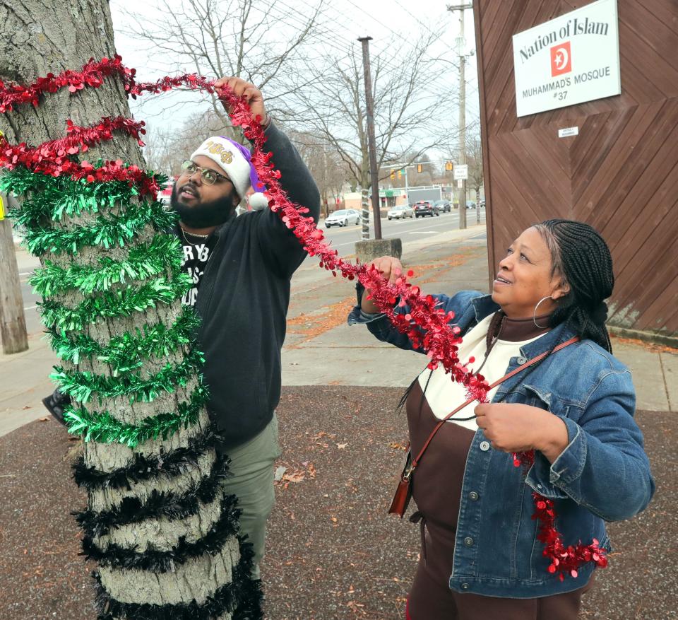 Will Blake and incoming Ward 4 Councilwoman Jan Davis, string garland on a tree on Copley Road in Akron.