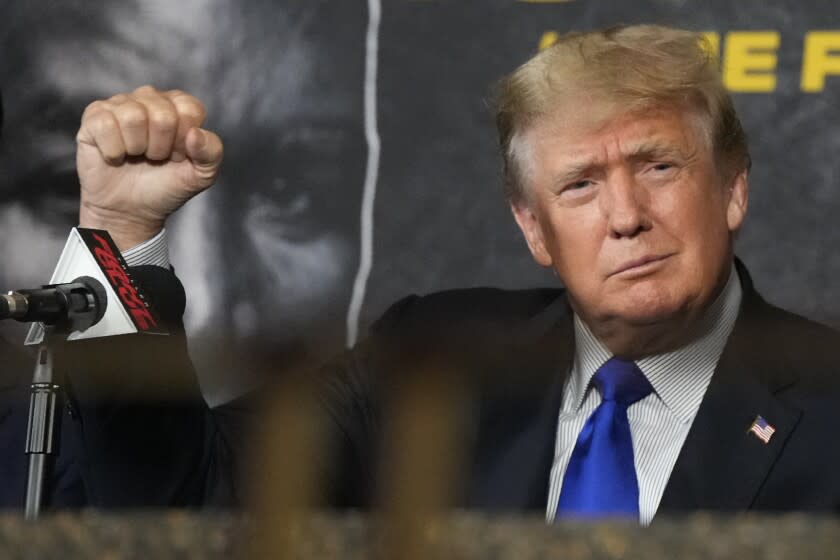 Former President Donald Trump salutes cheering fans as he prepares to provide commentary for a boxing event headlined by a bout between former heavyweight champ Evander Holyfield and former MMA star Vitor Belfort, Saturday, Sept. 11, 2021, in Hollywood, Fla. (AP Photo/Rebecca Blackwell)