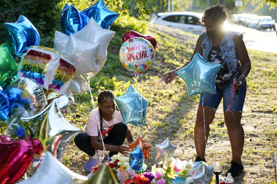 Debbie Jamison, right, with her daughter Precious, 12, leave balloons at a memorial for Cyrus Carmack-Belton, Friday, June 2, 2023, in Columbia, S.C. Authorities said Carmack-Belton, 14, was shot and killed by a store owner who wrongly suspected him of shoplifting. (AP Photo/Erik Verduzco)