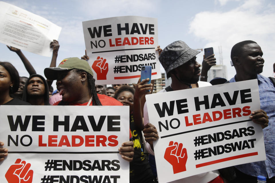 People hold banners as they demonstrate on the street to protest against police brutality in Lagos, Nigeria, Thursday Oct. 15, 2020. Protests against Nigeria's police continued to rock the country for the eighth straight day Thursday as demonstrators marched through the streets of major cities, blocking traffic and disrupting business. (AP Photo/Sunday Alamba)