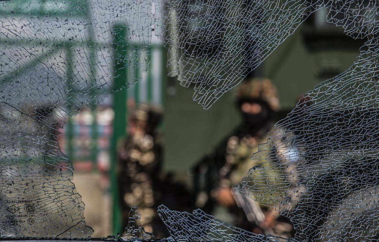 <span class="caption">The scene in Srinagar, in Indian-administered Kashmir, after an Aug. 10, 2021, grenade attack by militants that wounded at least nine civilians. Kashmir has experienced sporadic violence for more than seven decades, including three wars.</span> <span class="attribution"><a class="link " href="https://www.gettyimages.com/detail/news-photo/indian-government-forces-are-seen-through-a-broken-glass-of-news-photo/1234603051?adppopup=true" rel="nofollow noopener" target="_blank" data-ylk="slk:Yawar Nazir/Getty Images;elm:context_link;itc:0;sec:content-canvas">Yawar Nazir/Getty Images</a></span>