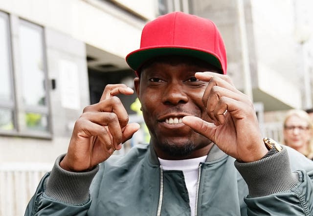 Mills makes the sign for a camera as he leaves Croydon Magistrates’ Court