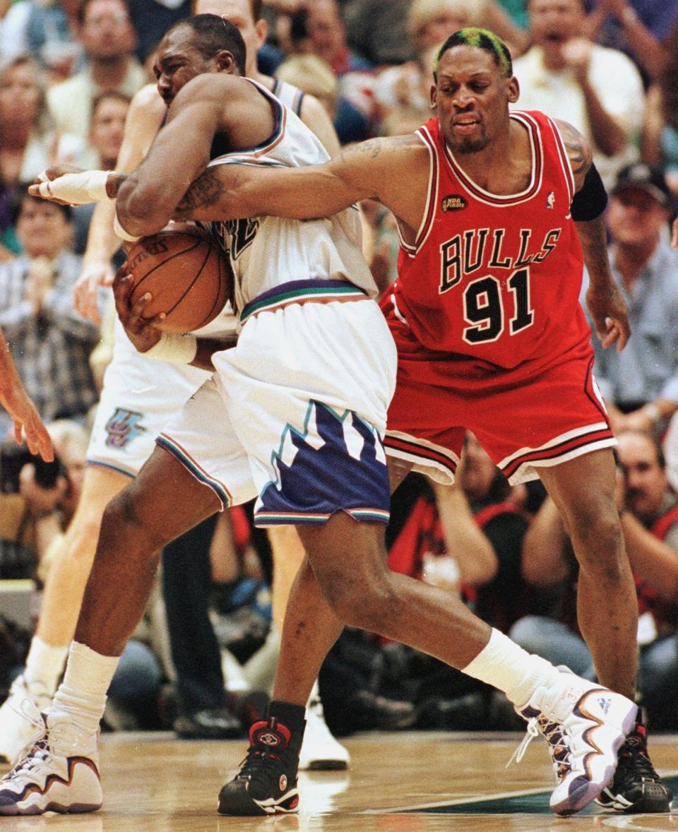 Dennis Rodman (R) of the Chicago Bulls gets his arm caught by Karl Malone (L) of the Utah Jazz 14 June as Rodman tries for the ball during game six of the NBA Finals at the Delta Center in Salt Lake City, UT. The Bulls won the game 87-86 to win their sixth NBA Championship. AFP PHOTO/Jeff HAYNES (Photo by JEFF HAYNES / AFP) (Photo by JEFF HAYNES/AFP via Getty Images)