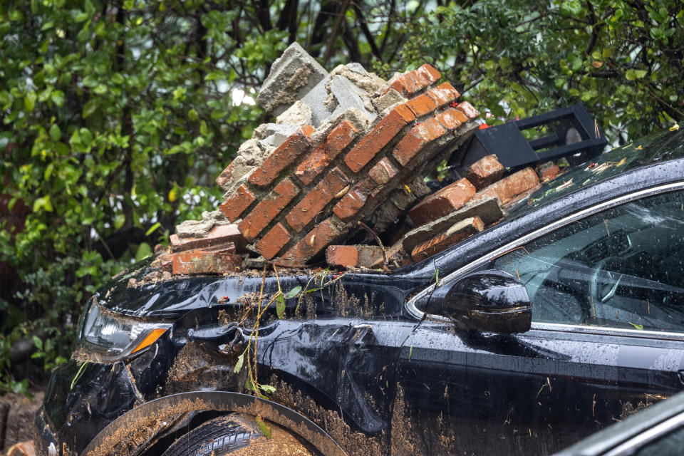 A car is damaged by bricks that fell during a landslide and flash flood on Feb. 5.