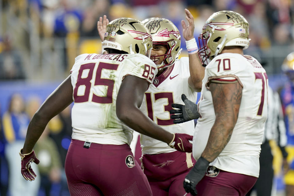 Florida state tight end Markeston Douglas (85) celebrates after a touchdown with quarterback Jordan Travis (13) and offensive lineman Casey Roddick (70) during the second half of an NCAA college football game against Pittsburgh in Pittsburgh, Saturday, Nov. 4, 2023. (AP Photo/Matt Freed)