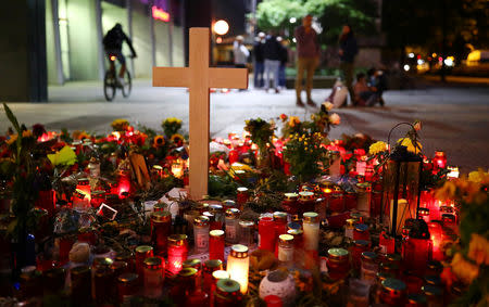 A cross, candles and flowers are seen at the crime scene where a German man was stabbed in Chemnitz, Germany, August 31, 2018. REUTERS/Hannibal Hanschke