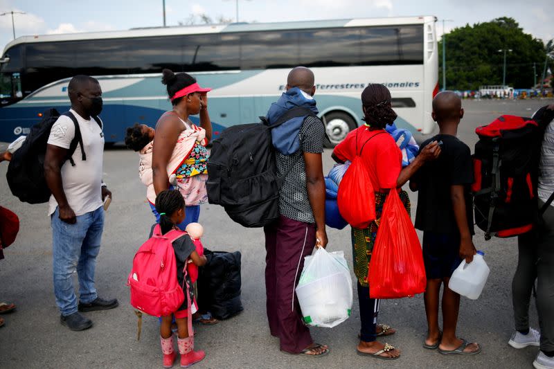 Migrants queue to get on buses after accepting an offer from the Mexican government to obtain humanitarian visas, in Tapachula