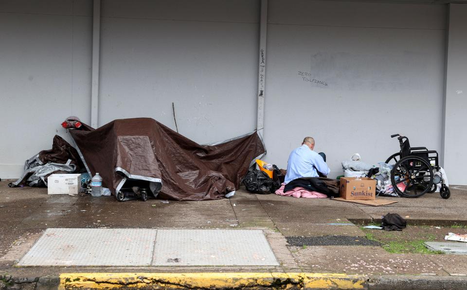 A person camps on the side of Rite Aid in downtown Salem on Jan. 10. Gov. Tina Kotek has declared a state of emergency on homelessness and plans to make it a priority during her tenure.