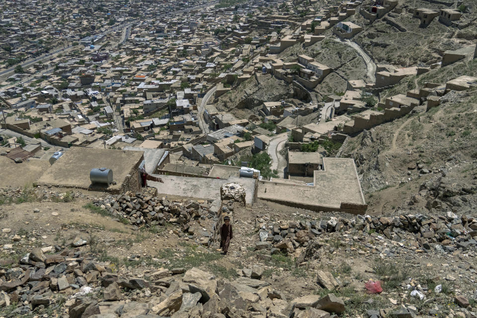 An Afghan child walksnext to his home atop a hill in one of Kabul's poor neighbourhoods in Kabul, Afghanistan Saturday, May 21, 2022. Some 1.1 million Afghan children under the age of five will face malnutrition by the end of the year. , as hospitals wards are already packed with sick children . (AP Photo/Ebrahim Noroozi)