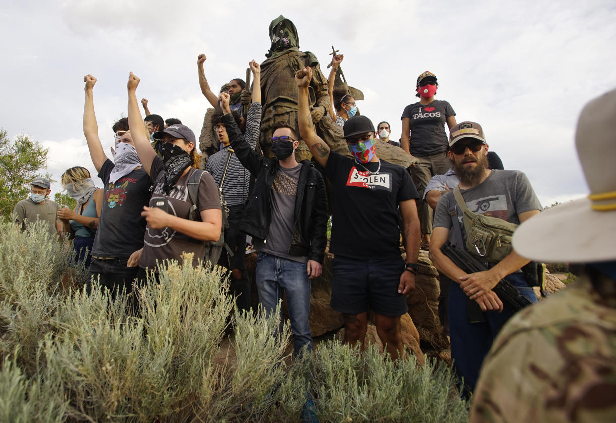 Demonstrators climb the statue of Don Juan de Oñate in Old Town Albuquerque. (Adolphe Pierre-Louis/ Albuquerque Journal via Zuma Wire)