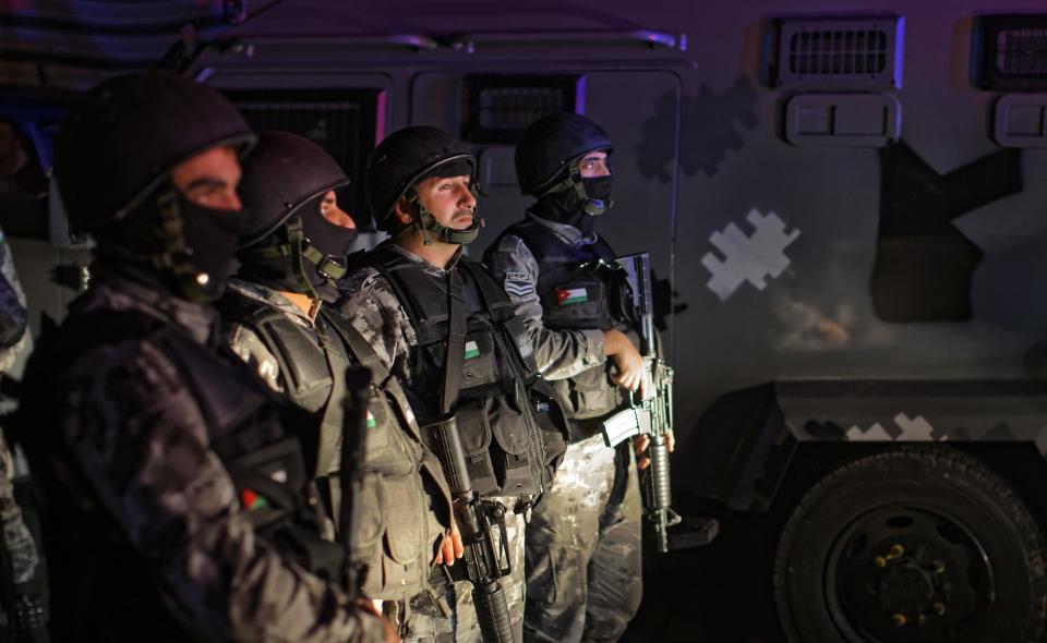 Jordanian security forces stand next to their armored vehicle at the scene next to Karak Castle, during an ongoing attack, in the central town of Karak, about 140 kilometers (87 miles) south of the capital Amman in Jordan, Sunday, Dec. 18, 2016. Gunmen assaulted Jordanian police in a series of attacks Sunday, including at a Crusader castle popular with tourists, officials said. (AP Photo/Ben Curtis)
