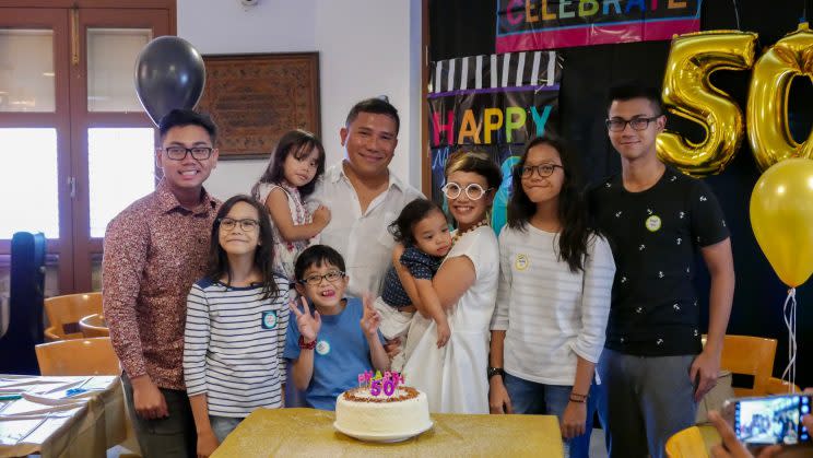 Oniatta Effendi, 43, (third from right) with her children and step children at her husband's 50th birthday party. Clockwise from left, Muhammad Zharfan bin Muhammad Nizam, 16, (wearing flowery shirt, her youngest stepson), Sharifah Romana binte Wan Raihan, 11, (her second youngest from a previous marriage), Wan Ilhan Effendi bin Wan Raihan, 8 (holding up peace sign, her youngest child from a previous marriage), Nogah Ohanna, 2 (carried by Ms Oniatta, her youngest from her current marriage), Sharifah Omera binte Wan Raihan, 12 (eldest child from her previous marriage), Muhammad Rasyif bin Muhammad Nizam, 19 (second youngest stepson), husband Nizam Ismail, 50, who is carrying Nadine Ohanna Nizam, 4 (eldest from current marriage) [Photo: Oniatta Effendi]