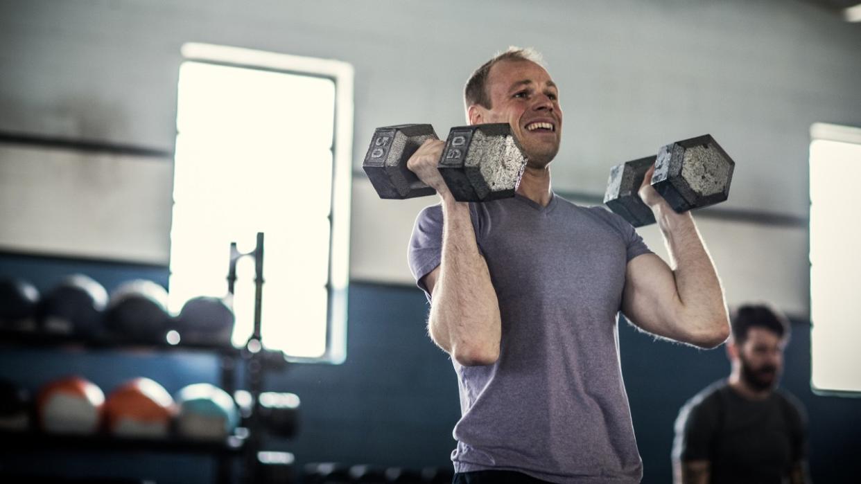  Man with dumbbells in front rack position 