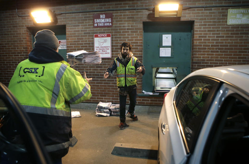 In this Thursday, April 11, 2019 photo worker Zach Charbonneau, of Pittsfield, Mass., throws papers to a colleague while loading vehicles with bundles of papers at The Berkshire Eagle newspaper, in Pittsfield. The paper now features a new 12-page lifestyle section for Sunday editions, a reconstituted editorial board, a new monthly magazine, and the newspaper print edition is wider. That level of expansion is stunning in an era where U.S. newspaper newsroom employment has shrunk by nearly half over the past 15 years. (AP Photo/Steven Senne)