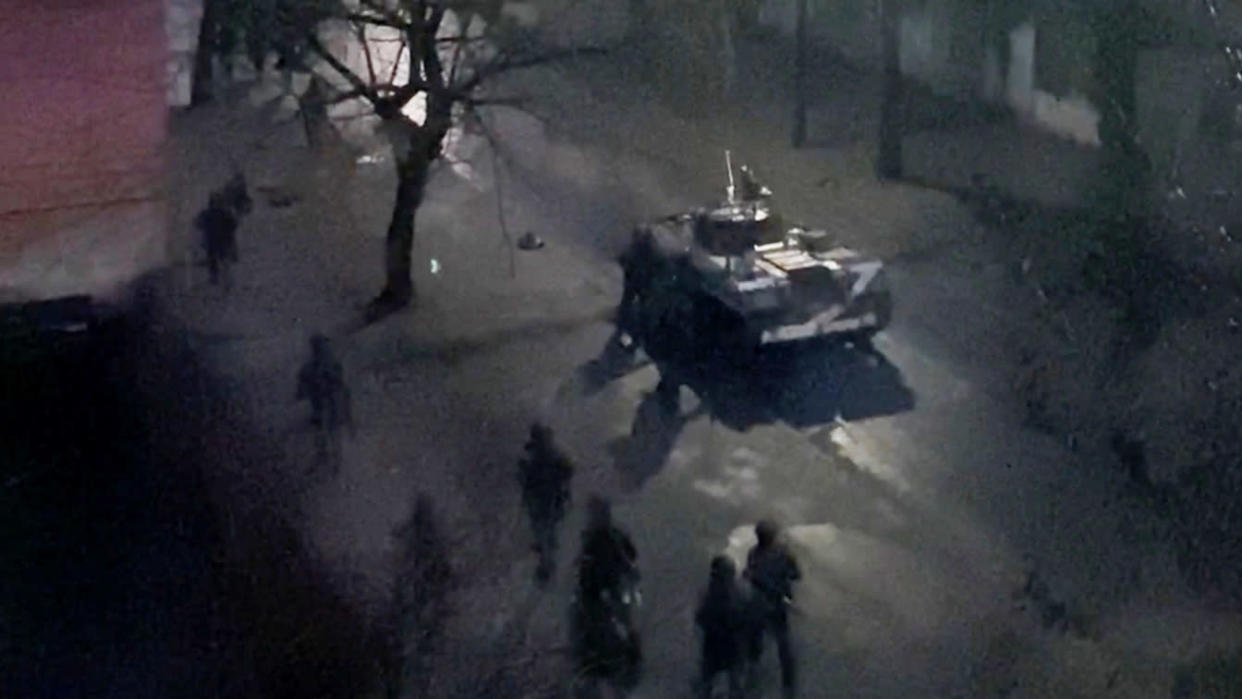 A military tank on a street in Kherson, Ukraine, at night.