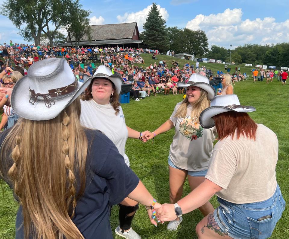 Country music fans dance at the Neon Nights festival on Friday at Clay's Resort Jellystone Park amphitheater in Stark County. The event continues Saturday.