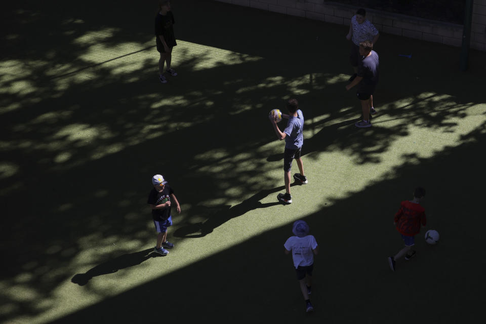 Ukrainian refugee children play with a ball in the backyard of the Lauder Morasha Jewish school in Warsaw, Poland, Thursday, July 28, 2022. A special summer camp run by Jewish organizations has brought Jewish volunteers from the former Soviet Union to Warsaw to help Ukrainian children. The camp, which ran for most of July and ended Friday, was organized to bring some joy to traumatized children, help prepare them for the school year ahead in Polish schools and give their mothers some time to themselves. (AP Photo/Michal Dyjuk)