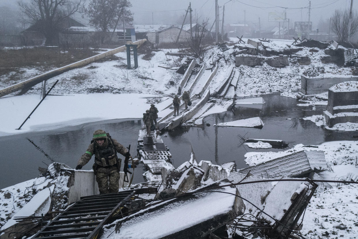  Ukrainian soldiers cross a destroyed bridge as they return from the front line in Bakhmut, Ukraine on Jan. 29, 2023.  (Marek M. Berezowski / Anadolu Agency via Getty Images)