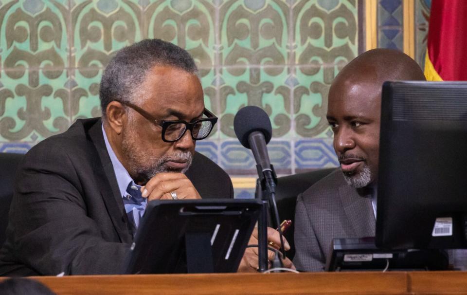 City Councilmember Curren Price, left, chats with colleague Marqueece Harris-Dawson on Tuesday at L.A. City Hall.