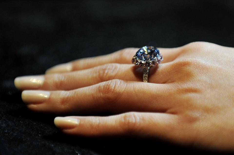A Sotheby's employee shows the world's largest round fancy vivid blue diamond, a 7.59 Carat stone, estimated in excess of 12 million at Sotheby's, central London, during a preview of the auction house's forthcoming London Rocks sale in October, when two diamonds, the white diamond at 118.28 carats, the largest D colour Flawless diamond, estimated between 18-22 million and round fancy vivid blue diamond are expected to fetch over 30 million between them at the sale.